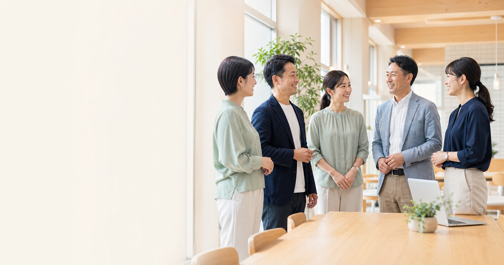 明るいオフィスで会話するサンステイのスタッフ